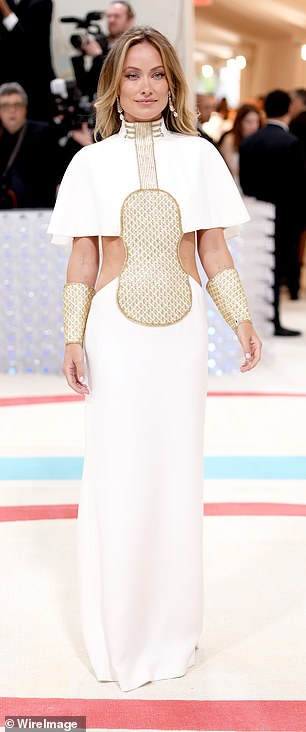 Stunner:Olivia 的礼服在胸前饰有古怪的金色镶板,金色袖口