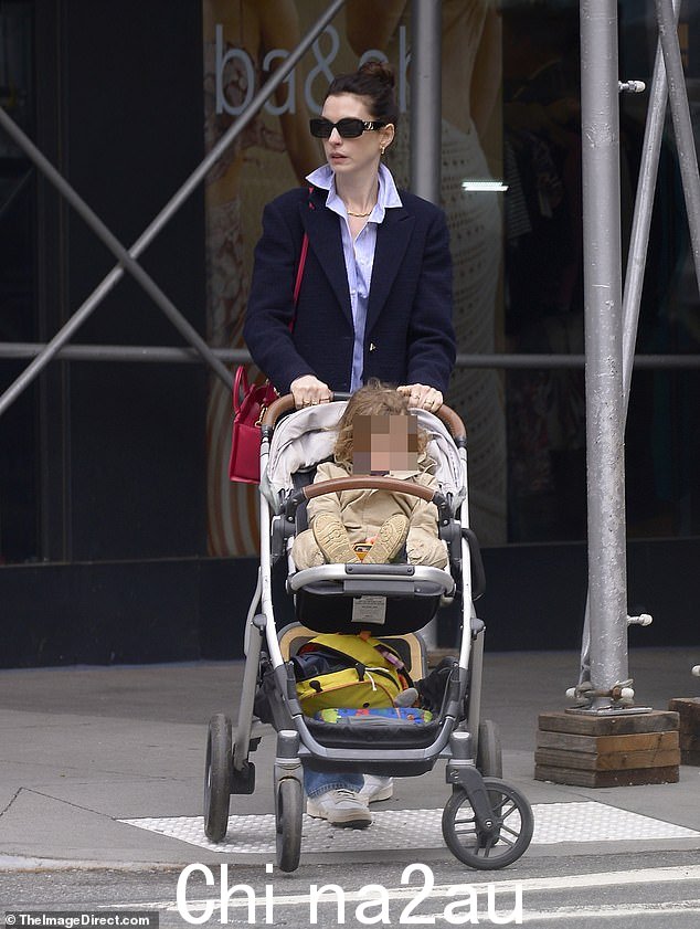 时尚:穿 Prada 的女魔头身穿海军蓝西装外套和宽松牛仔裤,外出时系紫色系扣衬衫