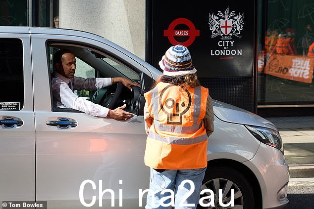 一名司机在继续抗议时与气候组织 Just Stop Oil 的活动家交谈