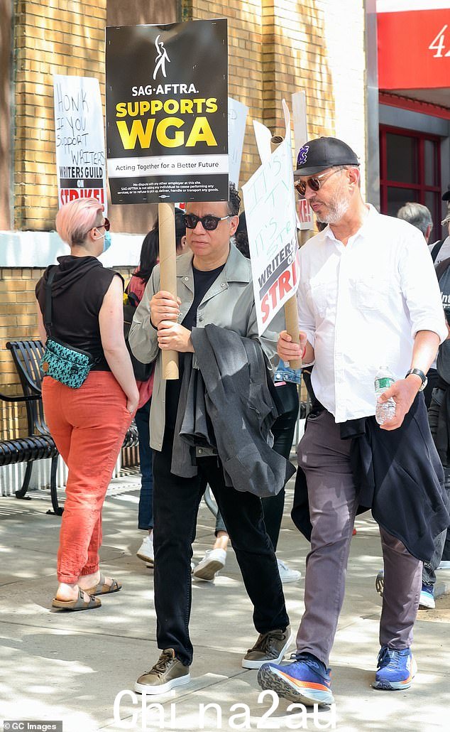 弗雷德的标志:演员和作家带着 SAG-AFTRA 支持 WGA 标志,同时穿着黑色裤子和棕色鞋子完成他的造型