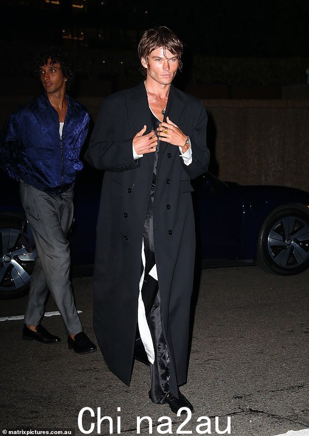 模特 Jordan Barrett(如图)在透明衬衫和宽松的缎面长裤外穿了一件轻盈的长款风衣
