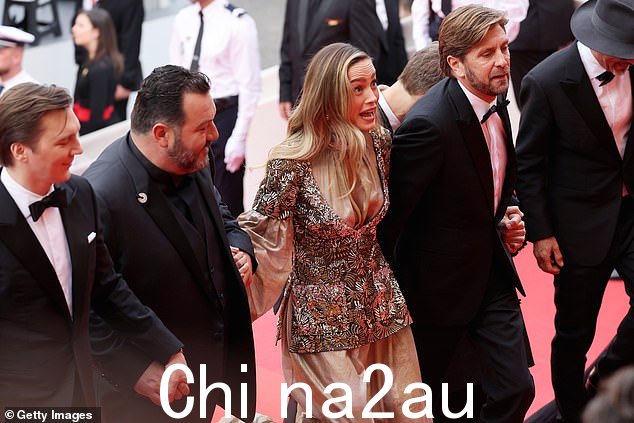 风格:当她在活动中摆姿势时,她的衣服在灯光下闪闪发光,裙子的上半部分呈现出夹克的形状,并饰有金色亮片(从左到右:成员评委 Paul Dano、Denis Ménochet、Brie 和评委主席 Ruben Östlund)