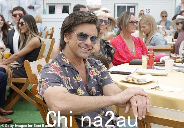 他的造型:Stamos 身穿浅卡其色西装,西装外套和休闲裤,搭配白色系带运动鞋。他的内搭是一件带马印的黑色衬衫