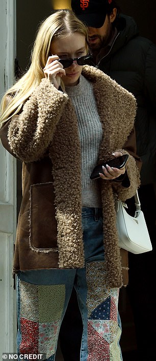 别致:她以深色太阳镜和白色 Prada 手提包结束了她的休闲造型,同时她的金色头发松散