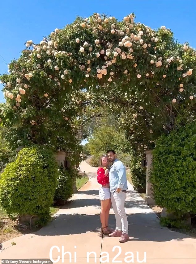 这对夫妇在南加州他们家风景如画的花卉入口前合影