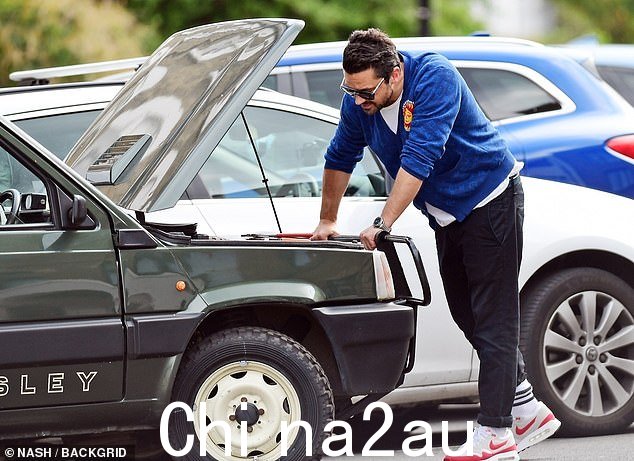 汽车问题:44 岁的多米尼克·库珀 (Dominic Cooper) 周四在伦敦修理他的经典菲亚特 4x4 Sisley 敞篷车时,穿着复古风格的开衫剪裁了一个随意的形象