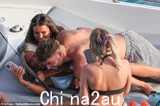 他在纸上的类型?穿着比基尼的金发女郎将她的手机放在汤姆和他刚刚吮吸她脚趾的黑发美女够不着的地方
