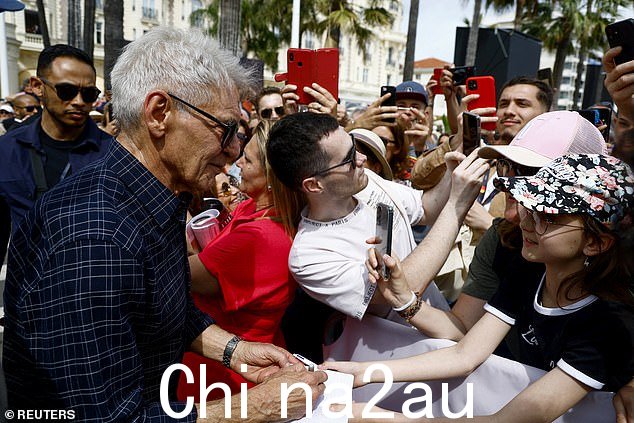 需求旺盛:哈里森为几位排队看他的粉丝签名