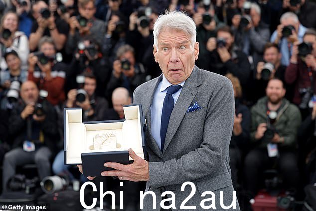 开玩笑:哈里森在与他的荣誉金棕榈奖颁奖时开玩笑地合影留念