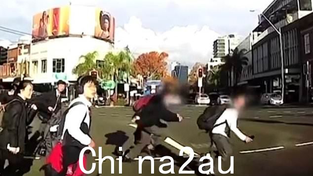 令人震惊的行车记录仪镜头捕捉到了三名小学生在繁忙的十字路口撞上一群正在过马路的学生后被迫塞车的那一刻(如图)