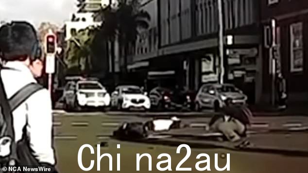 在检查道路上是否有迎面而来的车辆并冲进去帮助三个男孩之前,一群小学生似乎惊呆了。