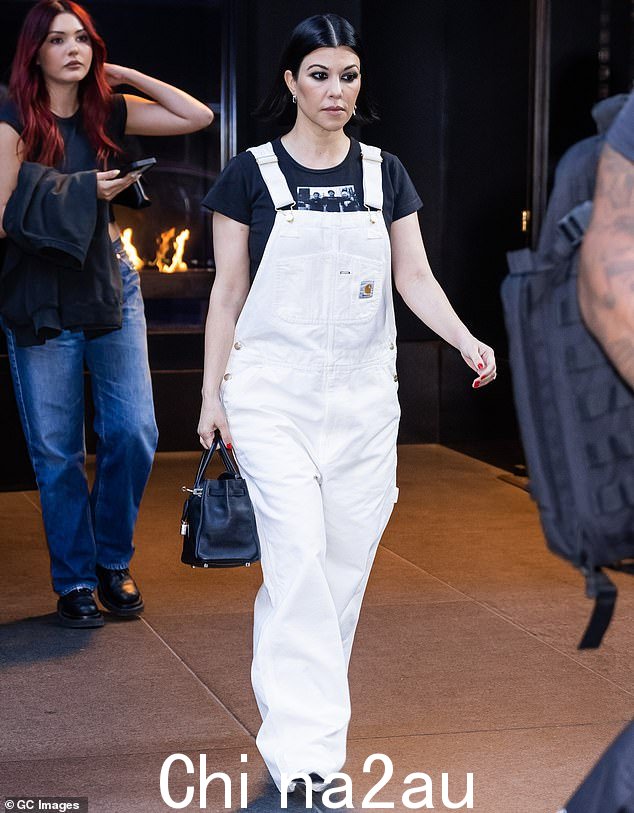 准备好演出:Kourtney 右手轻松地拿着一个黑色钱包来装一些她在激动人心的夜晚需要的物品