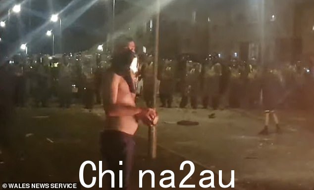 昨晚在加的夫,一名裸照蒙面男子站在防暴警察面前
