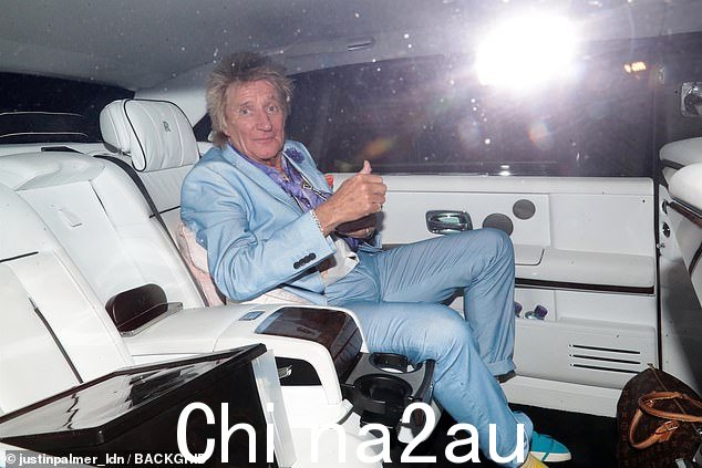 离开皇家阿尔伯特音乐厅,罗德爵士穿着浅蓝色西装、白色图案衬衫和紫色围巾剪裁得体。