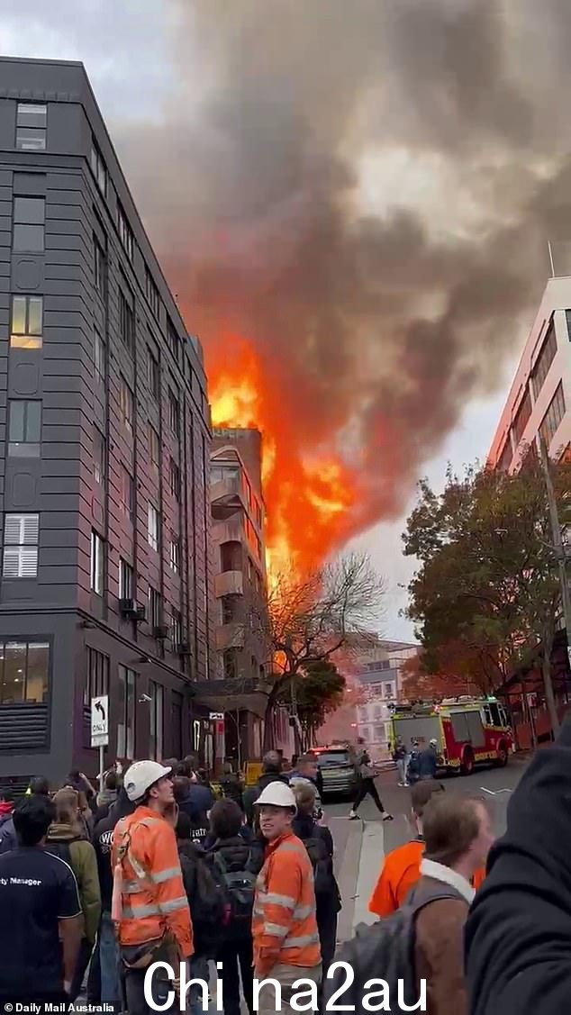 人们被拍到与悉尼中央车站旁边燃烧的建筑物保持距离
