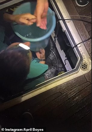 一名头戴手电筒的船员,疯狂地试图排空船舶机舱内上升的水