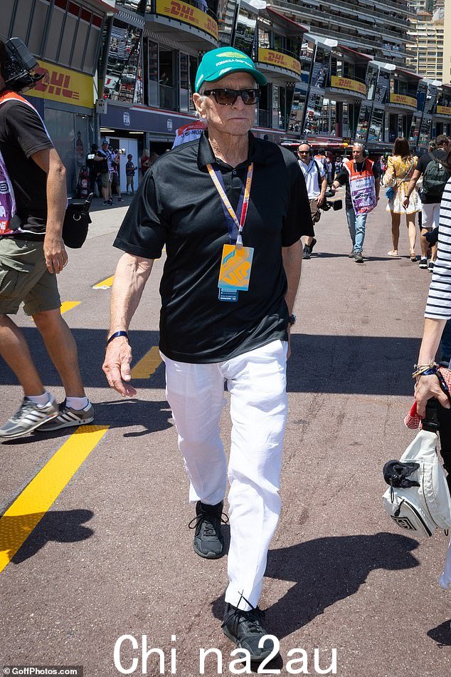 保持休闲:Michael 穿着黑色上衣搭配运动鞋,穿着休闲装,同时穿着一条白色裤子