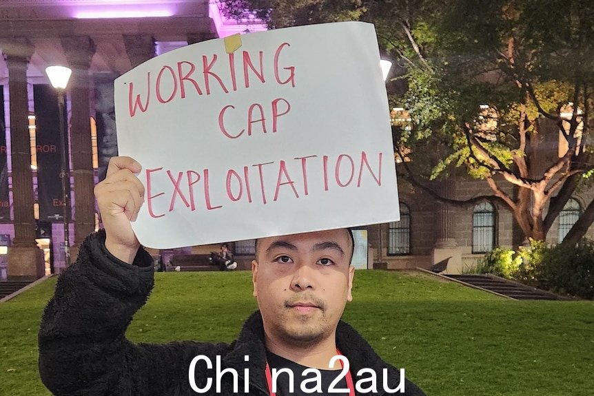 一个男人在这个头上举着一个牌子，上面写着“工作cap exploitation