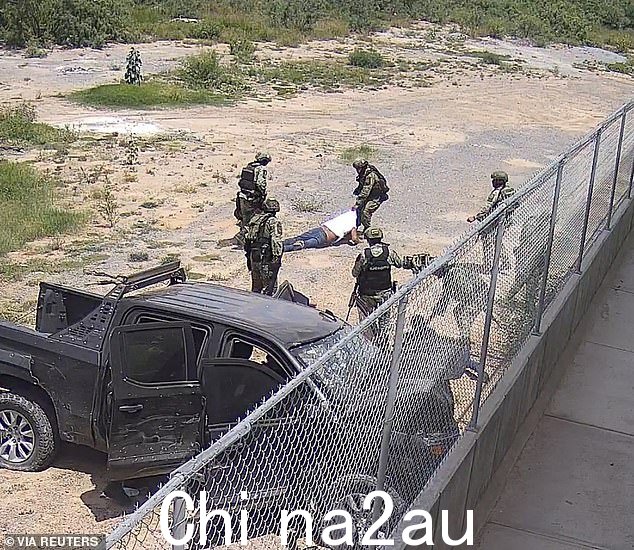 士兵们拖着他们在 5 月 18 日的皮卡车撞墙后杀死的五名涉嫌卡特尔嫌疑人中的一名
