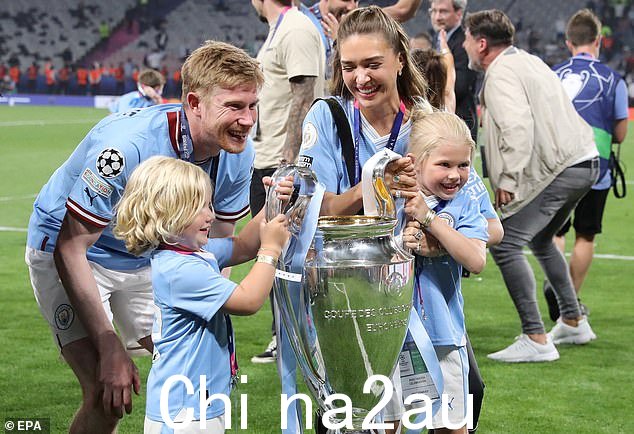 曼城球员 Kevin de Bruyne、他的妻子 Michele de Bruyne 和他们的两个孩子与奖杯合影