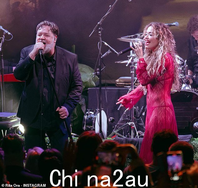 在舞台上:丽塔披着卷曲的金发披在肩上,并选择了典型的发光妆容