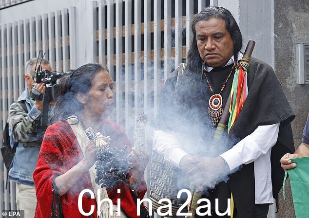 传统医生在新闻发布会上进行仪式负责寻找在丛林中迷路的儿童的原住民警卫协调员 Luis Acosta(右)的会议