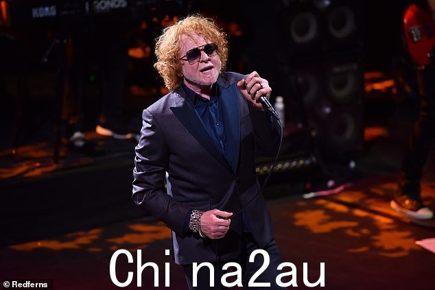 尴尬:流行歌星 Mick Hucknall 在音乐会上用错误的名字介绍他的键盘手后,简直脸红了