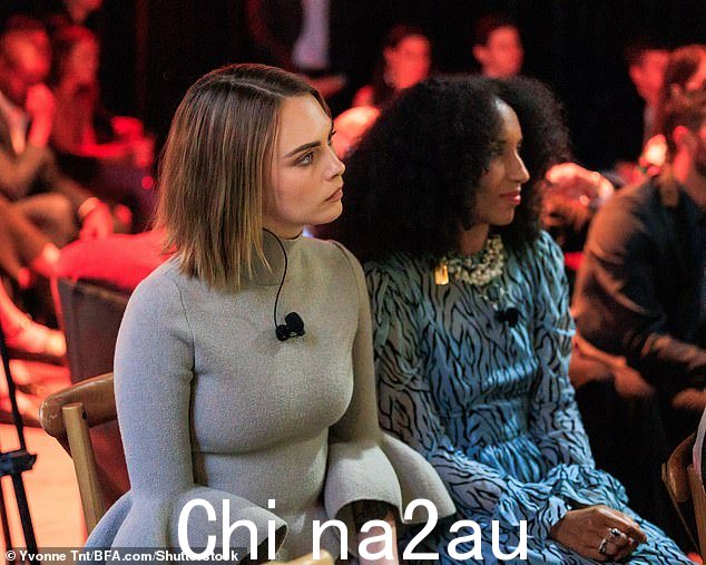 Into it: Cara was pictured entityly listening to the speakers on stage