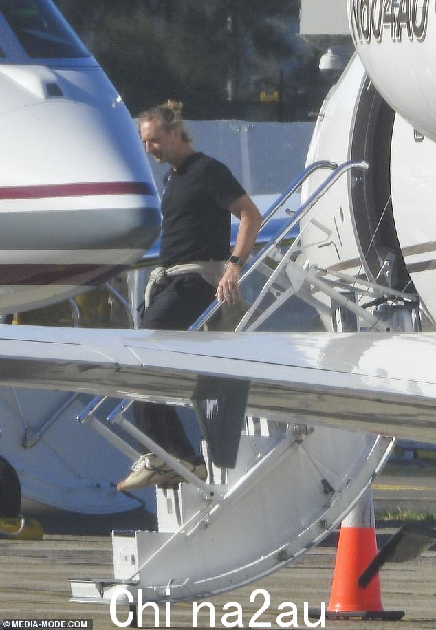酒吧大亨贾斯汀穿着黑色 T 恤和相配的彩色裤子离开私人飞机时也穿着舒适。