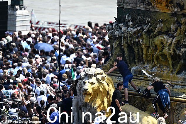 2023 年 6 月 14 日,人们在米兰市中心的大教堂广场站起维托里奥·埃马努埃莱二世的骑马雕像,在大屏幕上跟随意大利前总理和媒体大亨西尔维奥的国葬Berlusconi