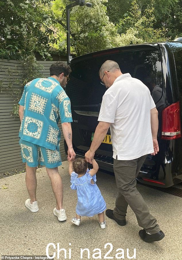 可爱:Nick 和 Priyanka 的父亲握着 Malti 的手,她开始在花园里散步