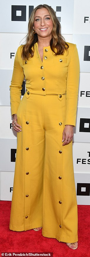 复杂:45 岁的 Chelsea Peretti 穿着一件精致的黄色开衫,上面有金色纽扣,并搭配配套的喇叭裤