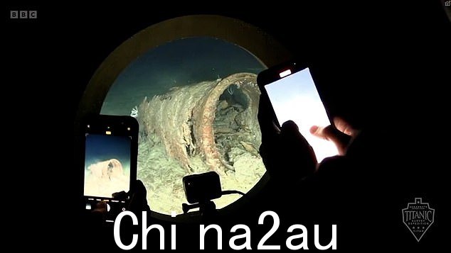 泰坦内部的人通过前面的圆窗用智能手机拍摄残骸