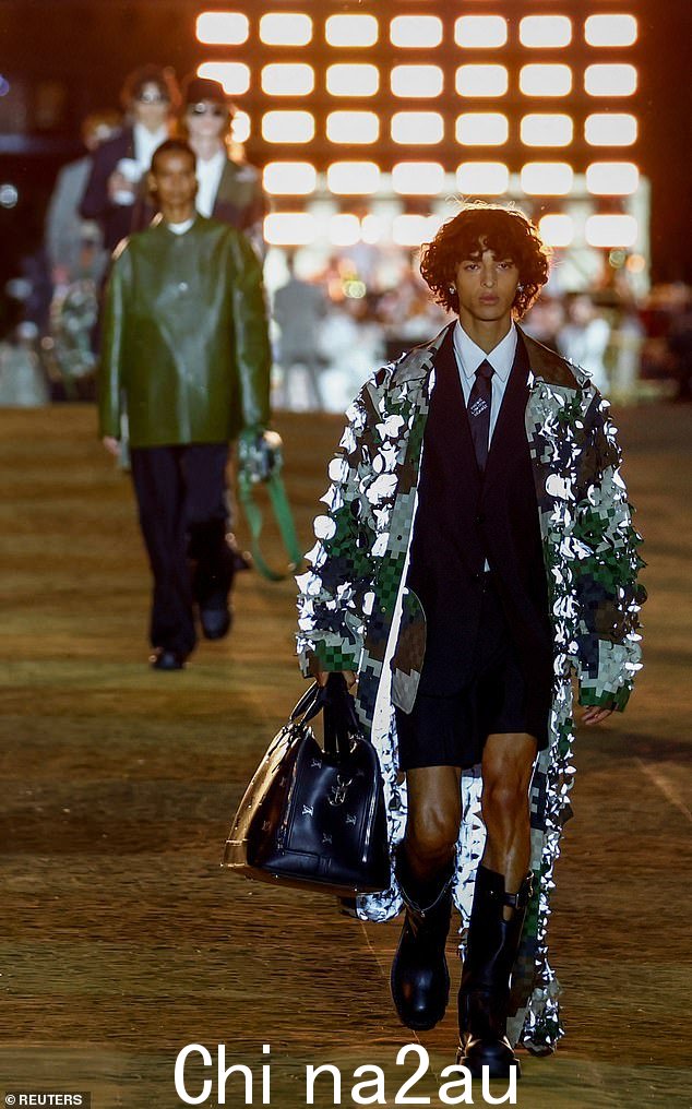 昂首阔步:模特们在 Pharrell 监督的系列中走上 T 台,大胆的金属色和街头服饰的风格让人惊叹不已