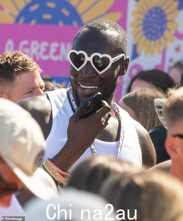 节日造型:Stormzy 戴着心形太阳镜,一只手戴着一系列节日腕带,融入了节日气氛