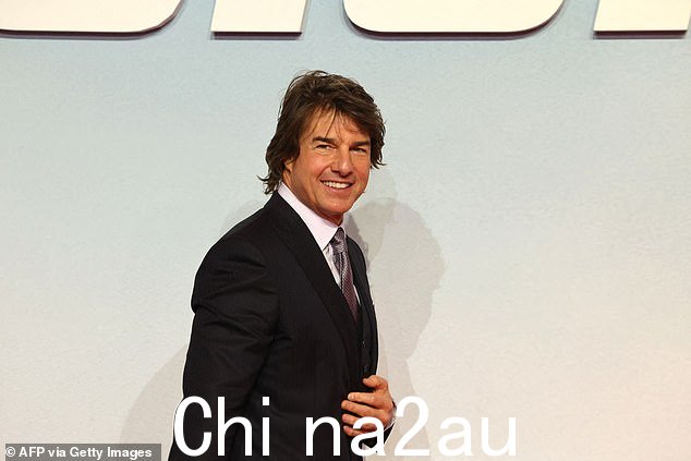 摆好姿势!汤姆在走过红地毯时露出了微笑
