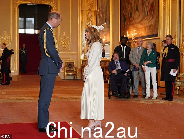 凯特·加拉威 (Kate Garraway) 今天被威廉王子授予 MBE,她的丈夫德里克·德雷珀 (Derek Draper) 坐在轮椅上观看(他位于凯特的右侧)