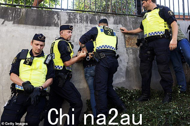 警方封锁了清真寺旁边公园的一个区域,将莫米卡和一名共同抗议者与人群分开。据了解,一名男子因携带一块石头被发现而被带离现场。图为:警方在现场拘留一名男子
