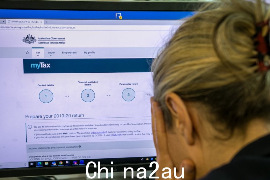双手抱头的女人，背景屏幕上显示纳税申报表。