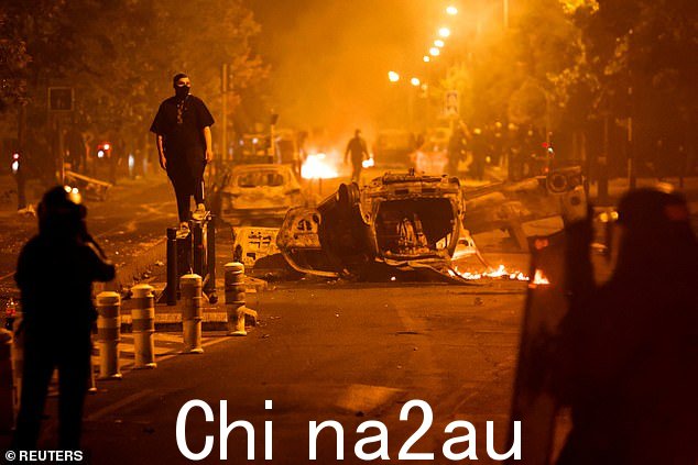 抗议者与被火焰包围的防暴警察发生冲突