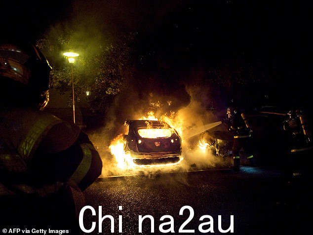 紧急救援人员扑灭夜间暴力抗议期间起火的车辆