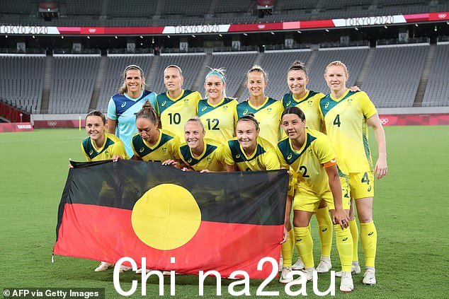 Matildas 球员在 2021 年东京奥运会对阵新西兰的比赛前与原住民旗帜合影