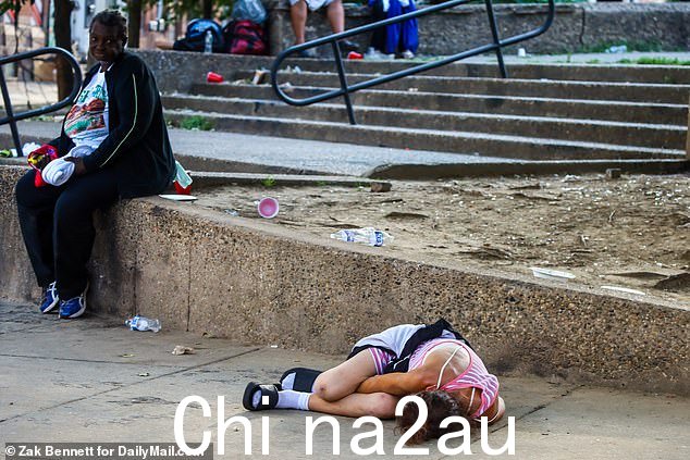 在人行道上昏倒的照片中可以看到瘾君子,其他人则忙着自己的事