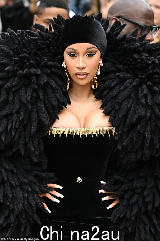 入场:她的好朋友、说唱歌手 Cardi B,30 岁,穿着全黑套装,搭配巨大的黑色羽毛披肩