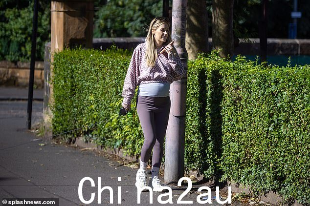 即将足月:这位即将在几周内分娩的电视名人,一边打电话一边在镇上漫步,她的精神状态似乎很好