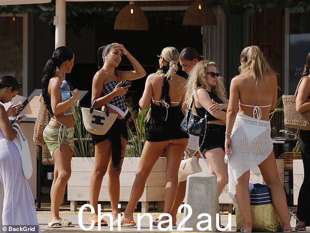 伙伴们:穿着沙滩装的女孩们在阳光下等待时聊天