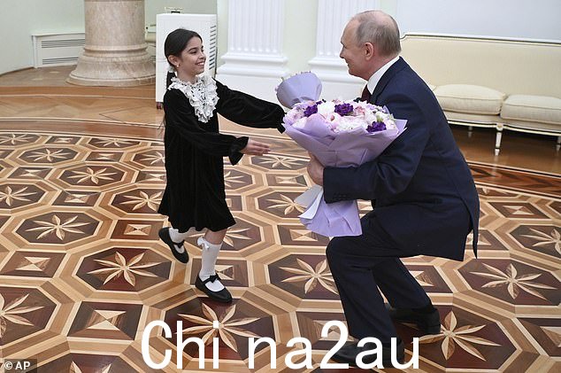俄罗斯总统弗拉基米尔·普京在莫斯科克里姆林宫迎接来自杰尔宾特的 8 岁女孩 Raisat Akipova
