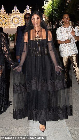 婚礼礼服:这位 42 岁的真人秀明星在参加普利亚的奢侈品牌 Alta Moda Show 后,在一场派对上展示了一套引人注目的套装,黑色面纱搭配紧身胸衣连衣裙,意大利