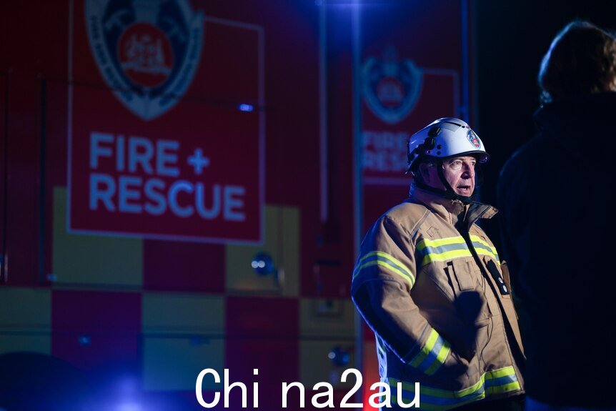穿着防护A的人身穿消防服的男子站在消防救援车前”/></p><p style=