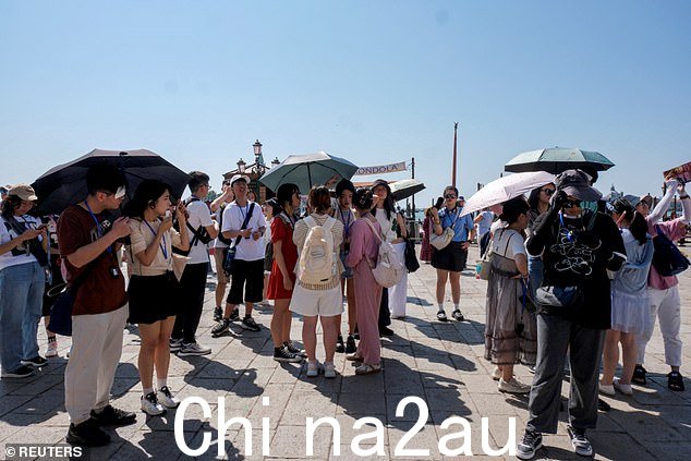 意大利 16 个城市发布了红色警报,这意味着酷热天气对全体居民构成健康风险,而不仅仅是像意大利这样的弱势群体老人和幼儿(如图:威尼斯遮阳伞下的游客)